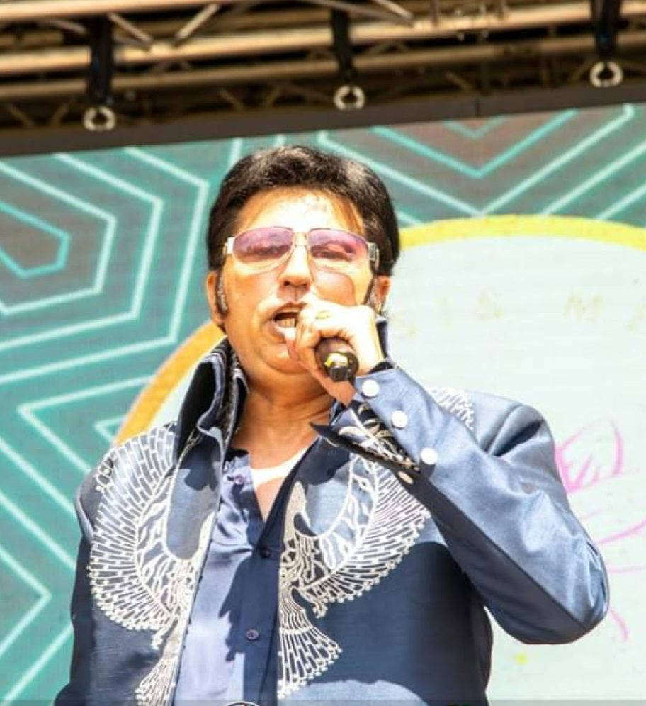 Bal Johal singing on an outdoor festival stage